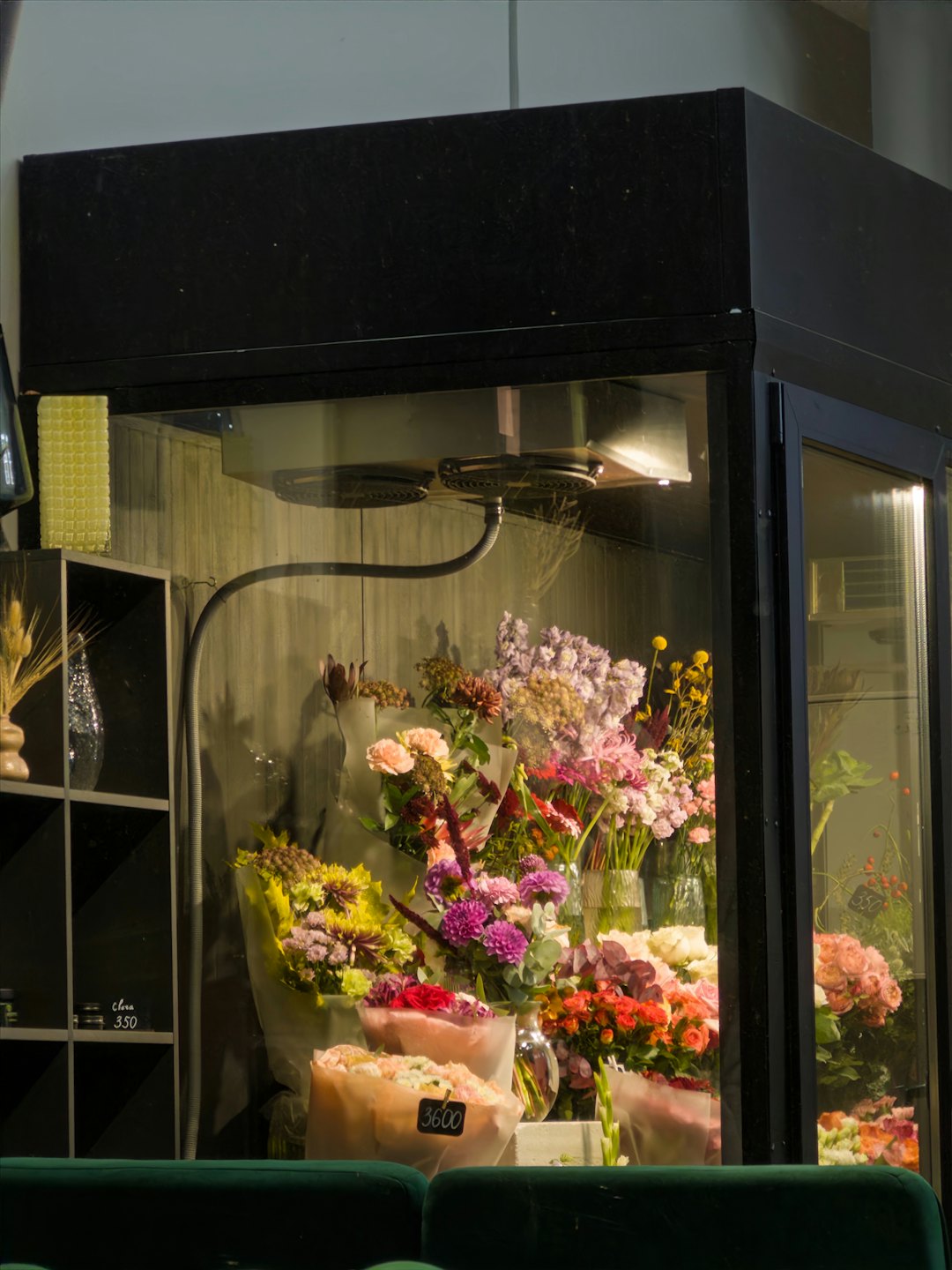Färgglada buketter av snittblommor arrangerade bakom en glaskassa.